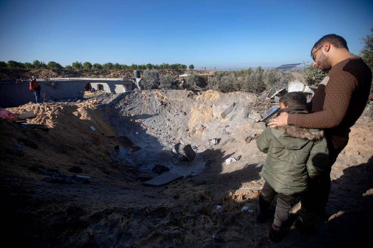 Palestinos inspeccionan un cráter causado por un ataque aéreo israelí en la localidad gazatí de Jan Yunes. //EFE