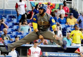 Jhonatan Solano hace swing para enseñar a jugar pelota
