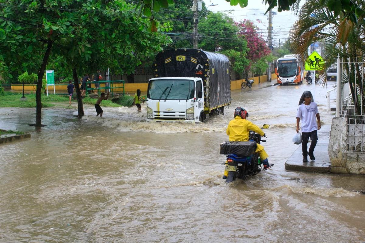 Un camión transita con dificultad la inundada carrera 81, en San Fernando, mientras un motociclista se detiene a analizar su paso. //Julio Castaño - El Universal
