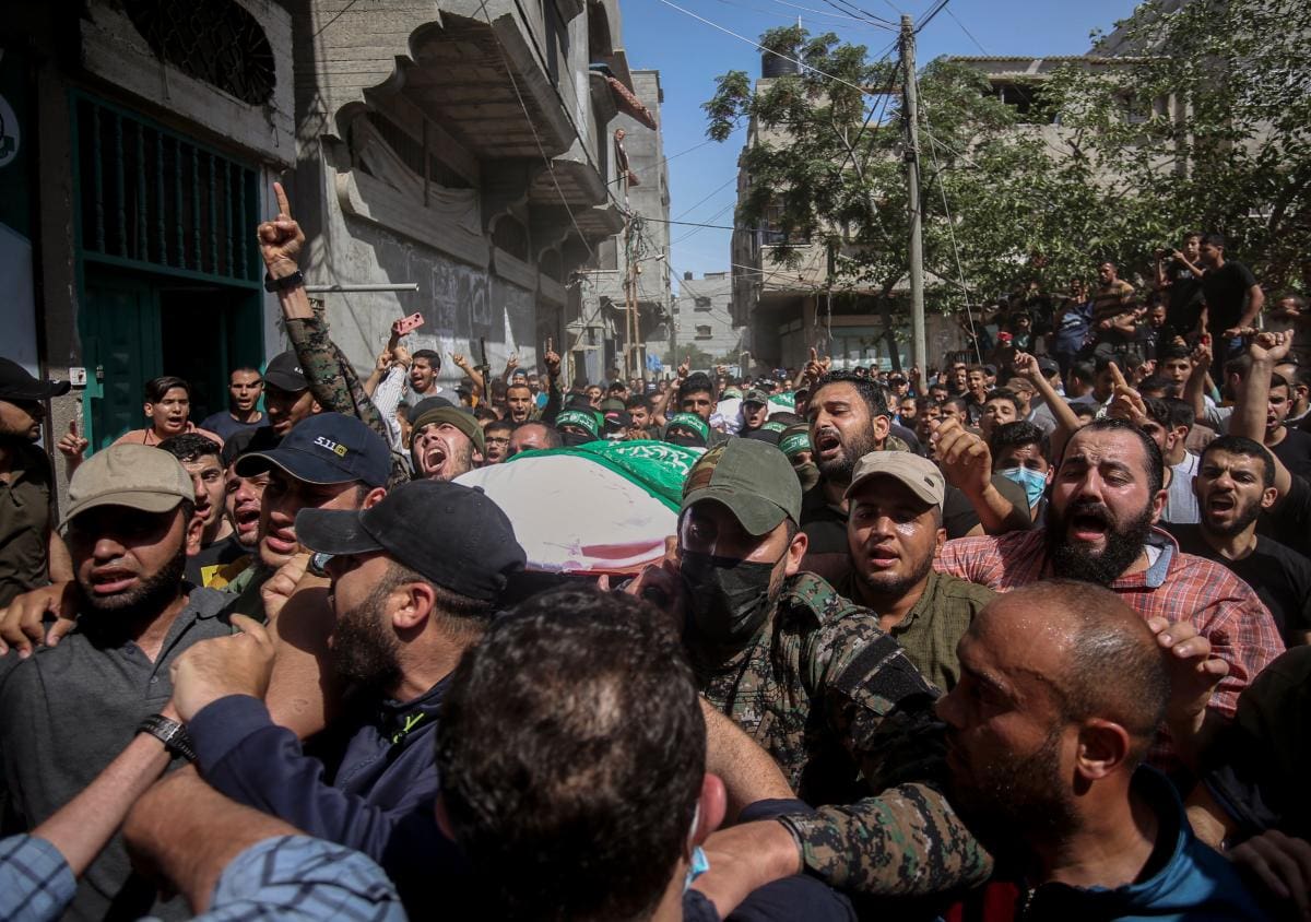 Los palestinos llevan los cuerpos de los miembros de las Brigadas Izzedine al-Qassann, el ala militar del movimiento Ramas, que murieron en el bombardeo israelí de un túnel.