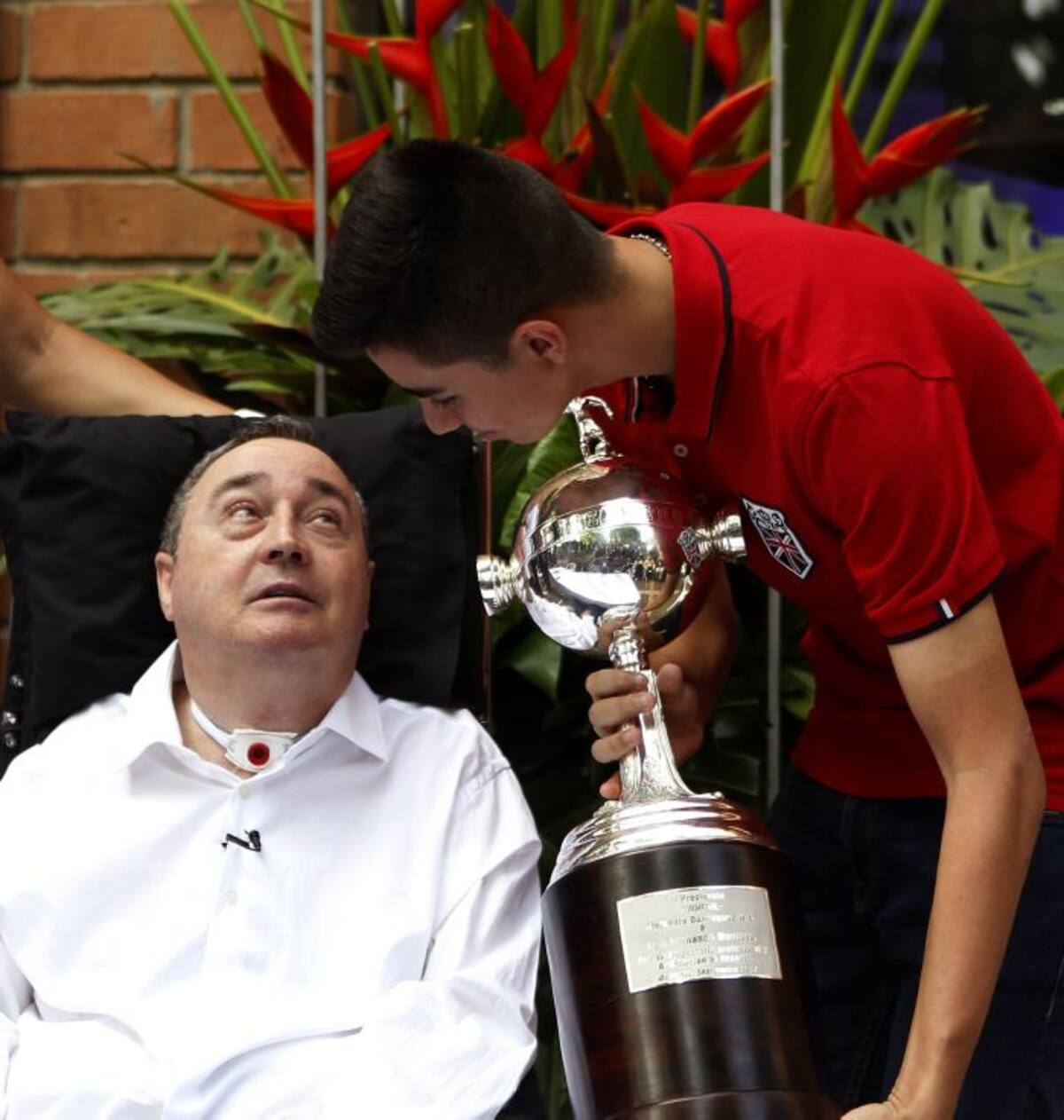 El entrenador colombiano Luis Fernando Montoya recibe junto a su hijo, José Fernando Montoya, una réplica de la Copa Libertadores en Medellín. EFE