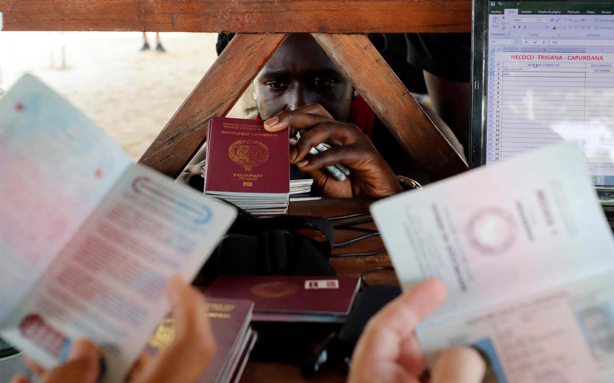 Migrantes de diversas partes del mundo compran boletos para una embarcación que los llevará al otro lado del golfo de Urabá, el 3 de mayo de 2021, en Necoclí . //EFE -Mauricio Dueñas Castañeda.