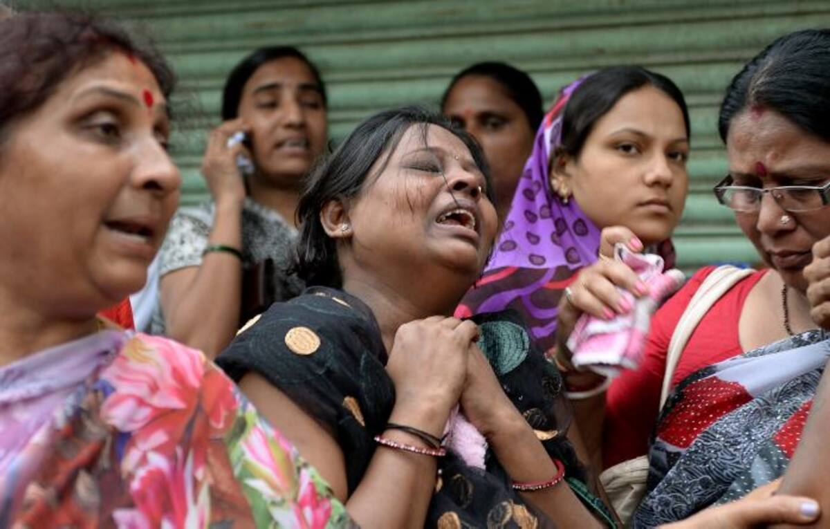 Habitantes de Mumbai lloran mientras esperan por noticias de sus familiares cerca del derrumbe. AP