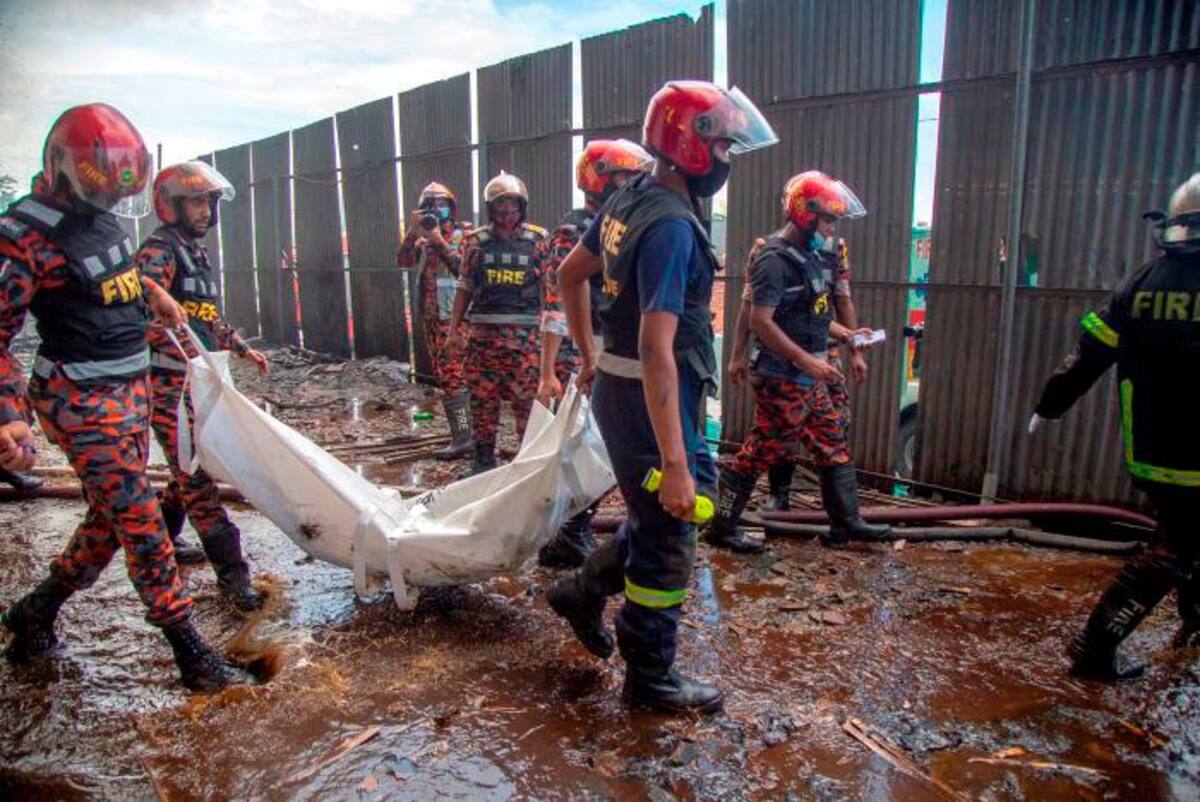 Bomberos sacan cuerpos de víctimas del incendio. //EFE
