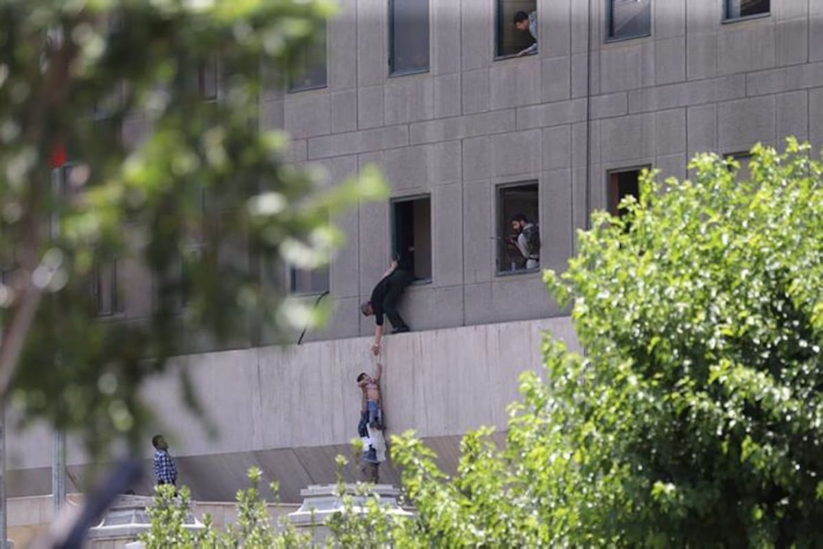 Policías iraníes ayudan a escapar a civiles después de que varios hombres armados irrumpieron en el Parlamento iraní y mataron a al menos siete personas. EFE