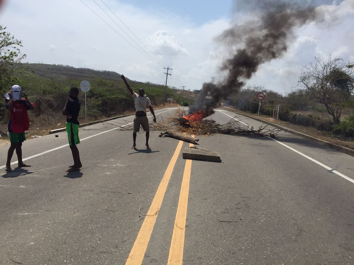 Más de 30 habitantes del corregimiento Arroyo de Piedra bloquearon la Vía al Mar, a la altura del kilómetro 19, para exigir la legalización de sus tierras. Cortesía Periodistas Cartagena.