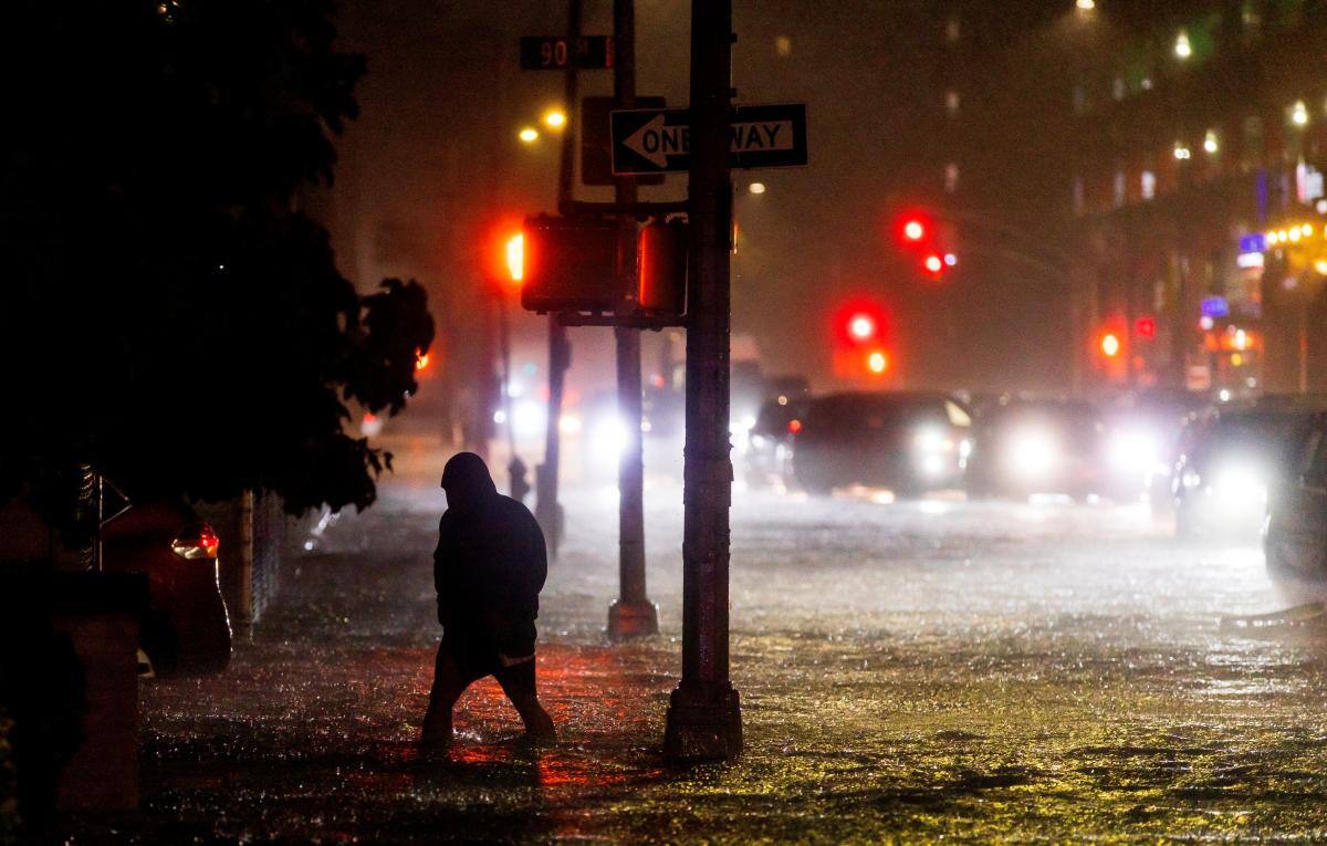 Un hombre navega por una calle inundada por fuertes lluvias mientras los restos del huracán Ida azotaban la zona del barrio Queens de Nueva York, Nueva York.