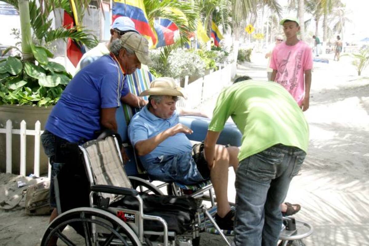 Un grupo de jóvenes voluntarios ayuda a las personas con el acceso a la playa. DAGOBERTO CABARCAS - EL UNIVERSAL