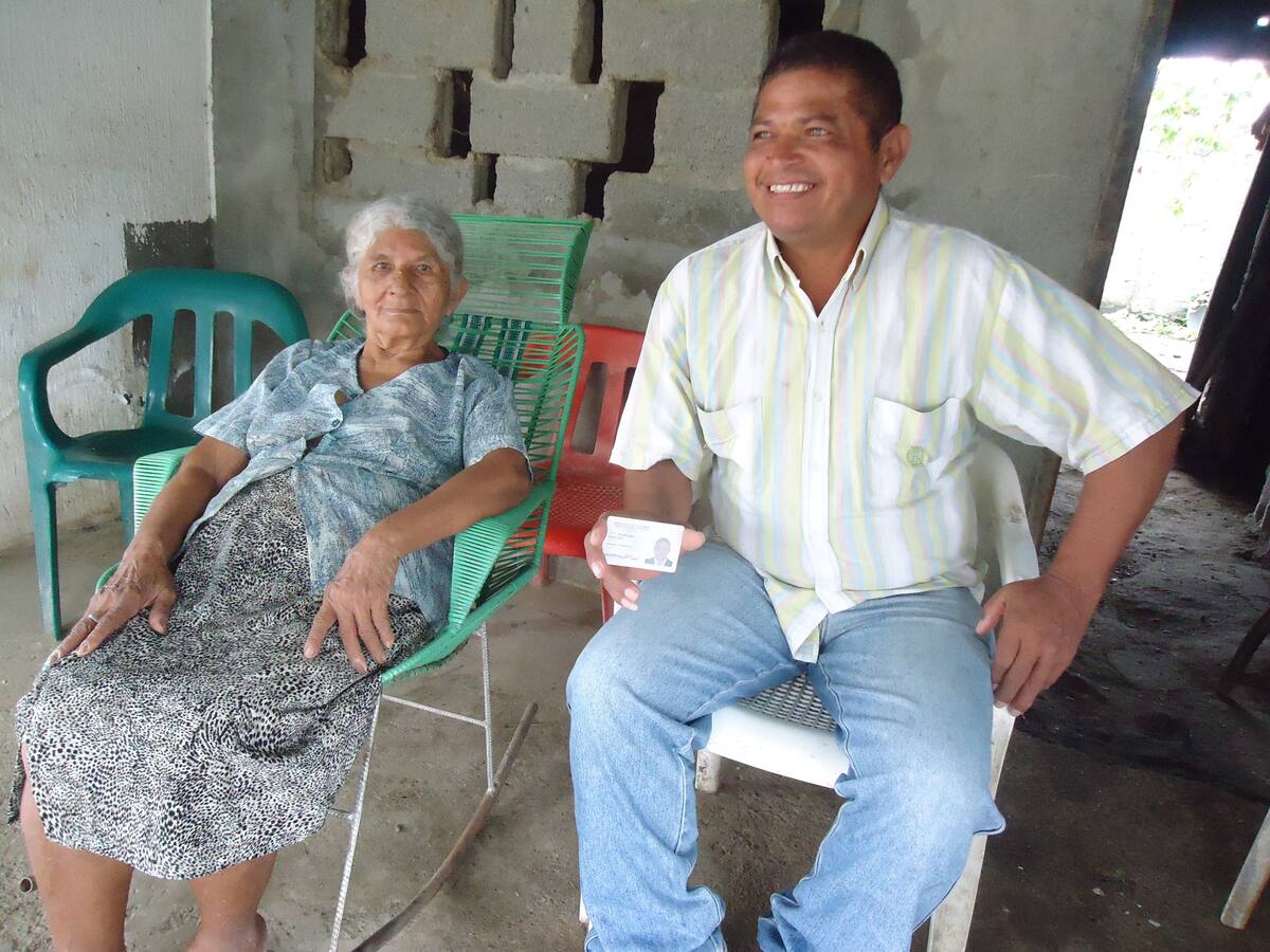 Al lado de su madre, Lorenza Díaz, muestra su cédula, como su pasaporte a la vida.