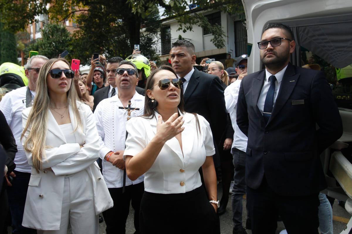 Catalina Gómez, hija del cantante Darío Gómez, canta junto al carro fúnebre que lleva los restos mortales de su padre a la Iglesia Santa Gema, en Medellín (Colombia).//Foto: Luis Eduardo Noriega - Efe.