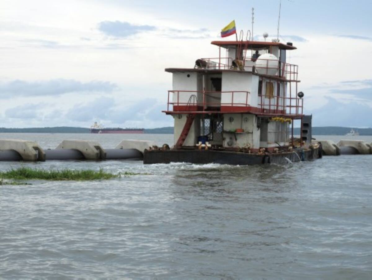 Un remolcador de río, usado dentro de la bahía de Cartagena, empuja un tramo del Emisario Submarino para ponerlo en posición de salida.