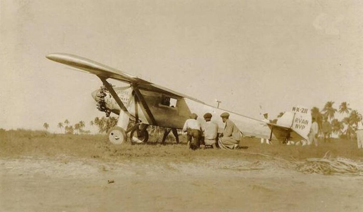 1929, tomada el 23 de enero a las 3 de la tarde a la llegada del aviador Charles Lindbergh. Se observan en primer plano tres hombres en cuclillas y al frente de ellos tapado por el avión las piernas en V del famoso aviador orinando. CORTESÍA FOTOTECA HISTÓRICA DE CARTAGENA
