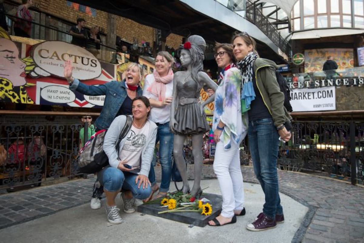 Fanáticas se fotografían junto a la estatua de Amy Winehouse. AP Tim Ireland