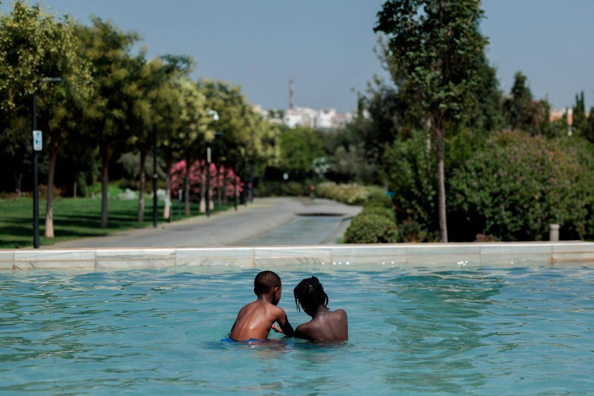 Dos niños se refrescan en una fuente del Parc Central. //EFE