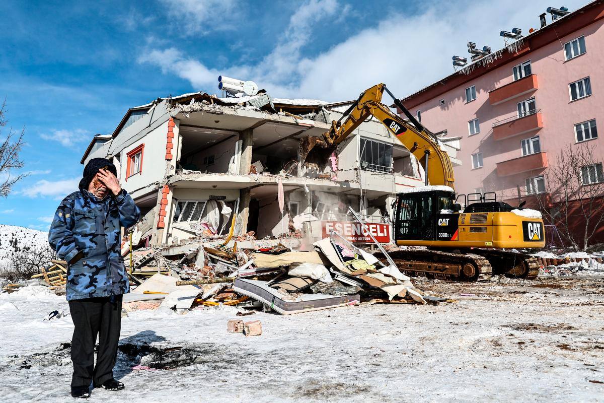 Una mujer reacciona junto a un edificio derrumbado durante las operaciones de búsqueda después del poderoso terremoto en el distrito de Elbistan de Kahramanmaras.