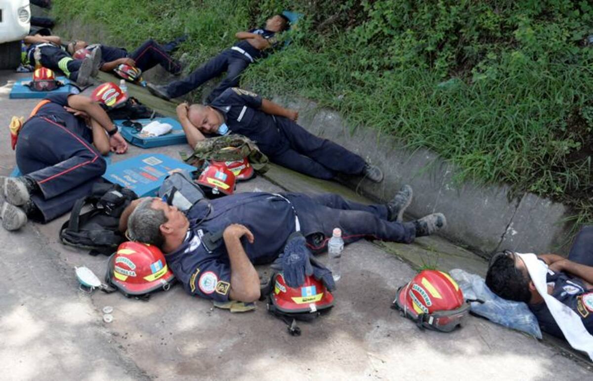 Rescatistas toman un descanso mientras continúan las labores de búsqueda y rescate. EFE Rodrigo Pardo