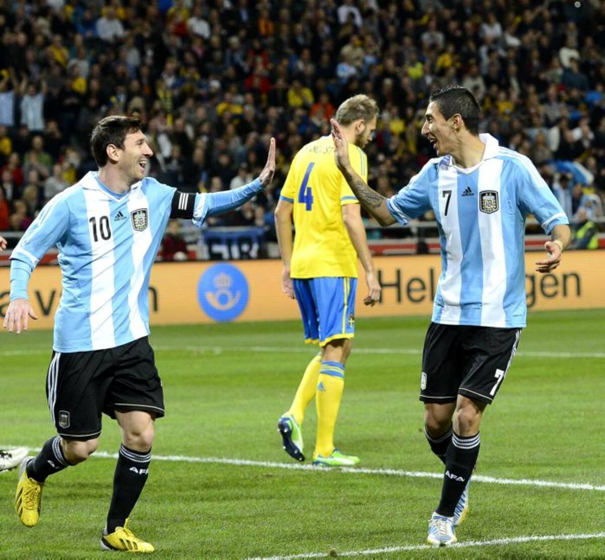 El astro Lionel Messi se saluda con Ángel Di María en uno de los goles con los que Argentina venció 3-2 a Suecia. AP