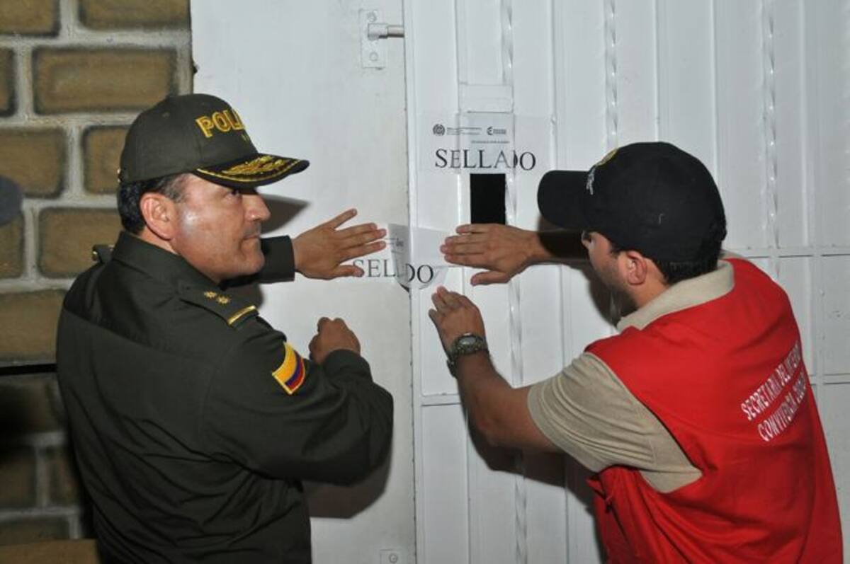 El comandante de la Policía, general Luis Humberto Zapata, junto al secretario del Interior, Fernando Niño, imponiendo el sello de suspensión de la actividad. //Cortesía.