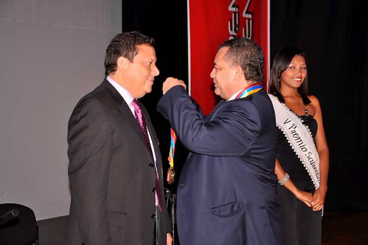 El secretario de Educación, Julio Alandete, recibiendo la distinción de manos de Ubaldo Meza, presidente de la ODAEE.
