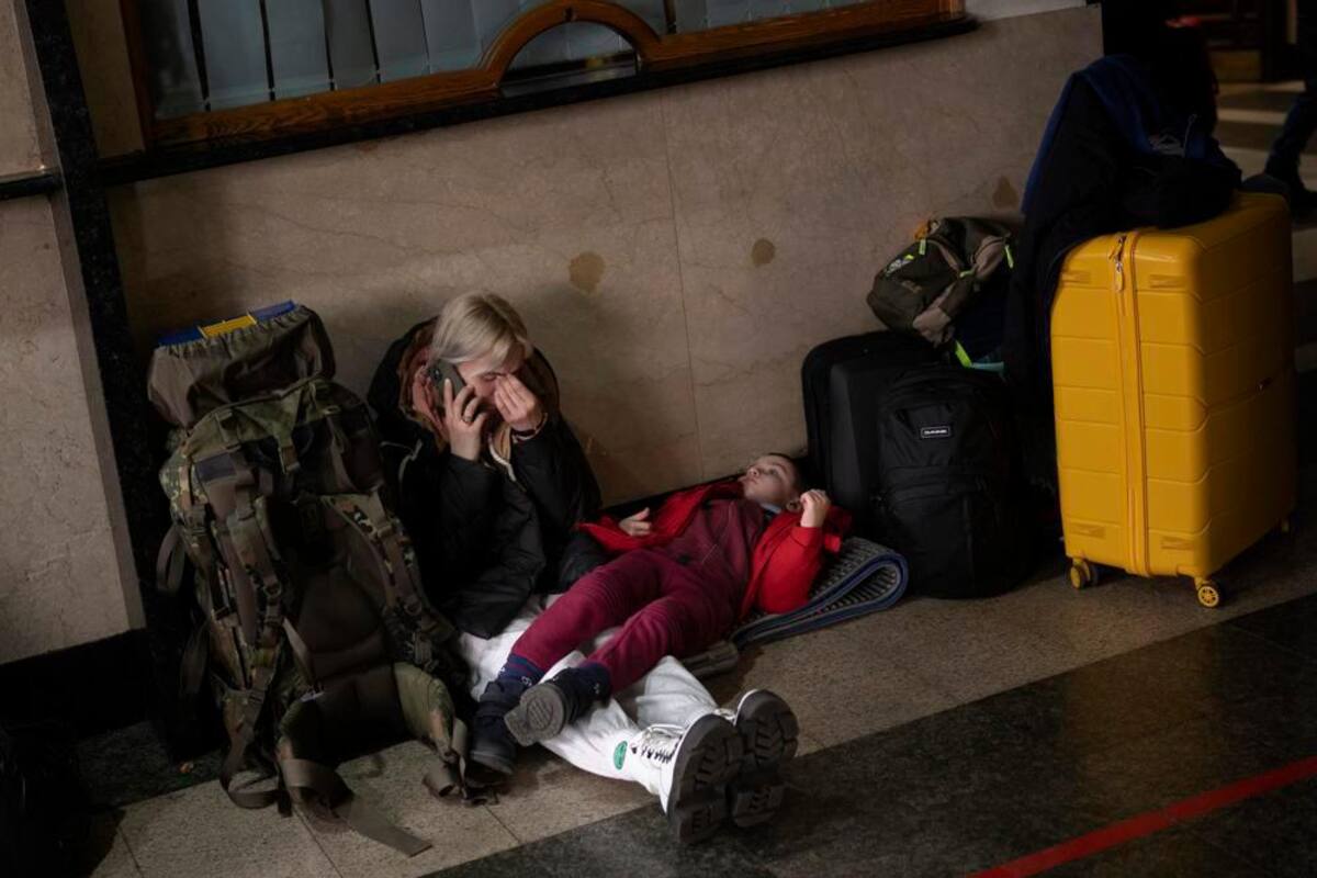 Una mujer con su hija espera a un tren mientras tratan de abandonar Kiev. //AP
