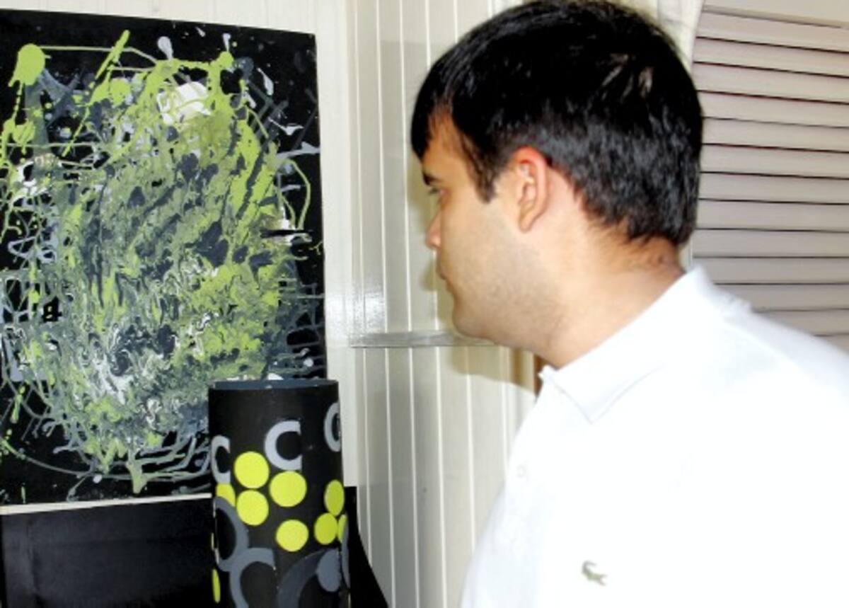 Rafael Pérez “tato” con una de sus pinturas de la exposición “Los colores del silencio”