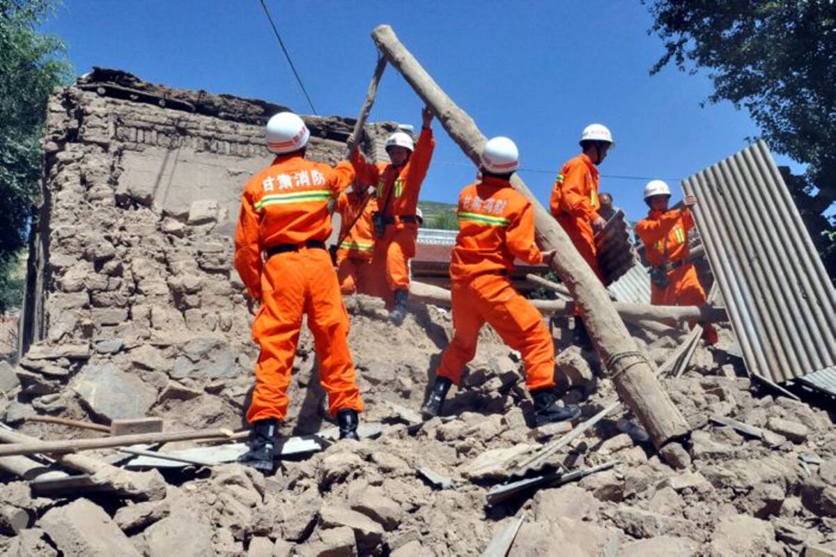 Rescatistas ayudan a quitar los escombros que quedaron de una casa tras el sismo. AP Guo Gang