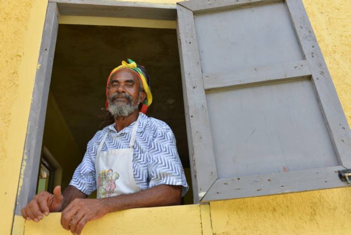 Un rastafari se asoma a su ventana para escuchar a los escritores. Dave MacFadden-AP