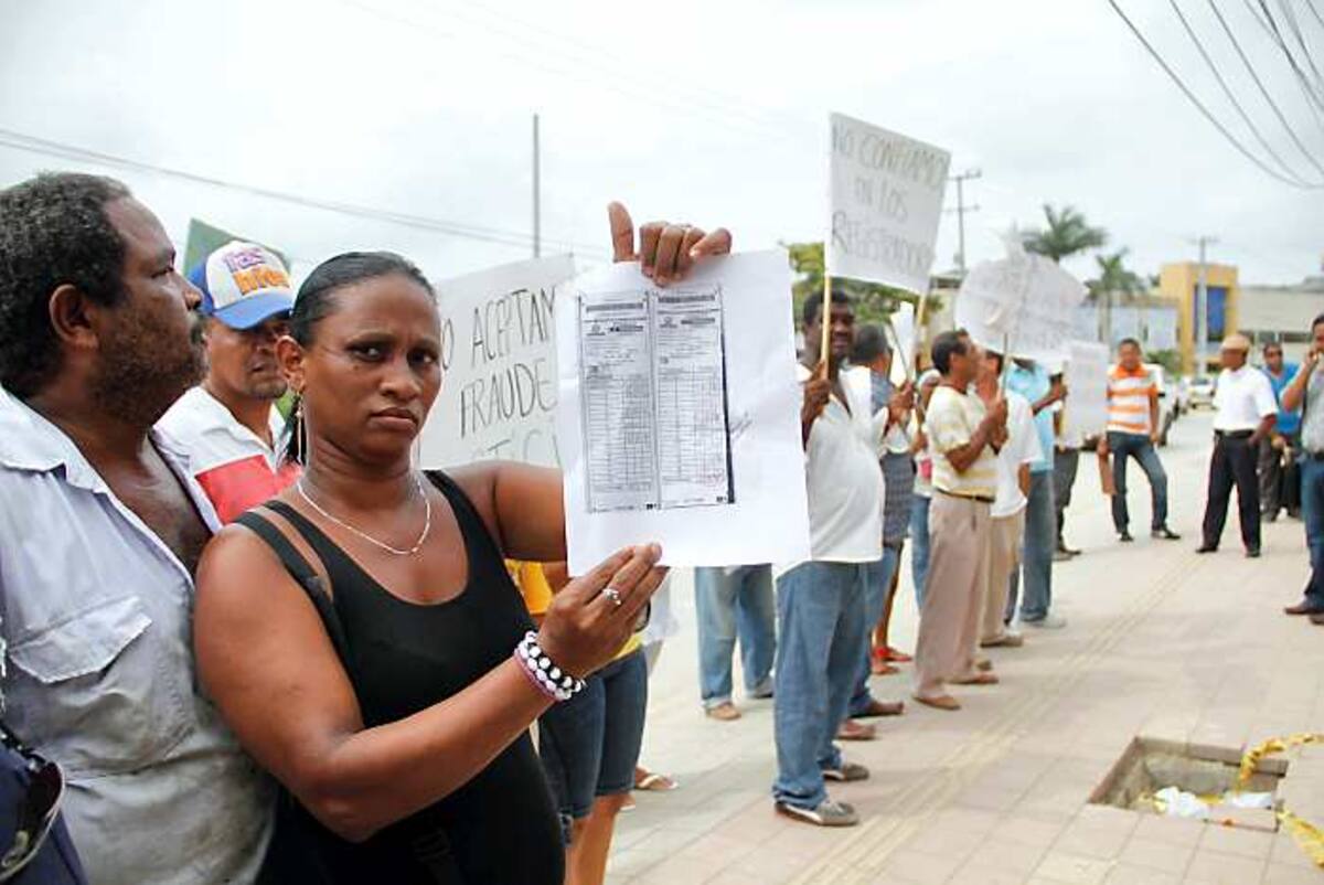 En la imagen, una ciudadana muestra las copias de dos formularios E14 con posibles alteraciones de resultados, tras una protesta frente a la sede donde se realizan los escrutinios para Cartagena. Oscar Díaz