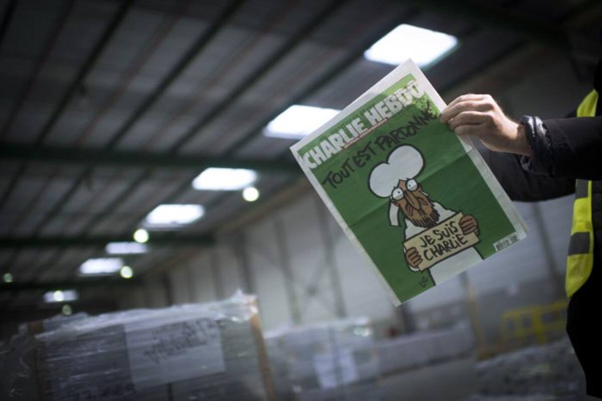 Una persona lee la próxima edición del semanario Charlie Hebdo. AFP MARTIN BUREAU