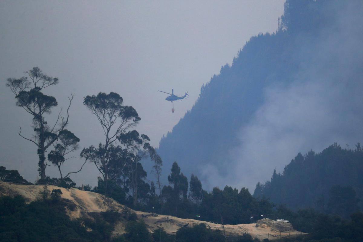 Un helicóptero combate hoy un incendio forestal en el cerro El Cable, en Bogotá (Colombia). //EFE/ Carlos Ortega