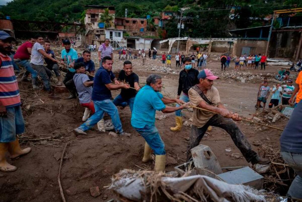 Habitantes colaboran hoy para retirar los destrozos tras el desbordamiento de la quebrada Los Patos, en Las Tejerías, estado Aragua (Venezuela). //EFE.