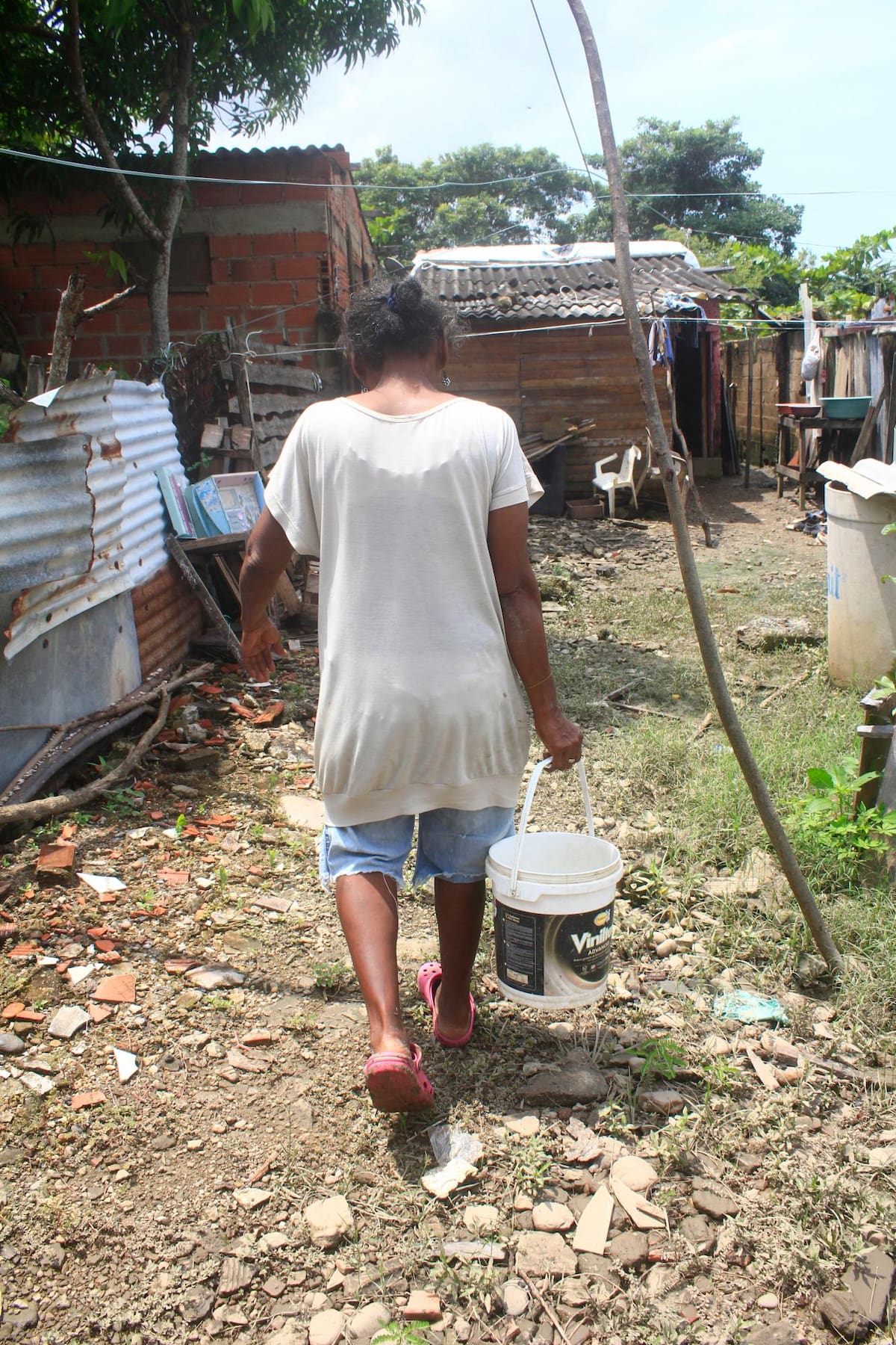 Con baldes saca el agua de su casa // Foto: Julio Castaño - El Universal.