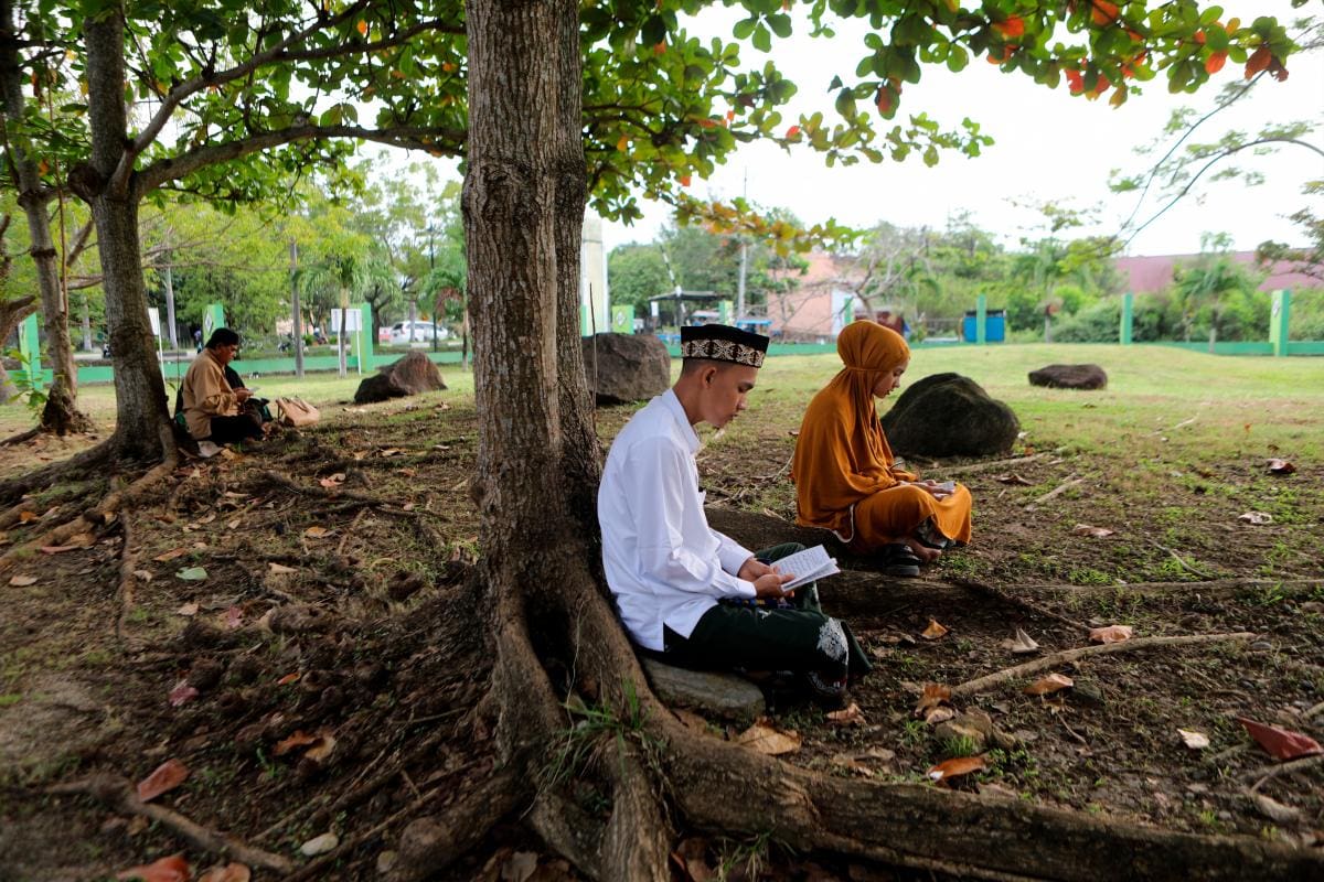 El pueblo de Aceh reza y lee el Sagrado Corán en una fosa común para las víctimas del tsunami. // Foto: EFE.