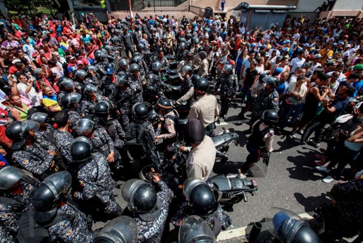 Vista de los enfrentamientos entre un grupo de personas adeptas al oficialismo y personas opositoras al gobierno nacional durante la consulta popular hoy. EFE