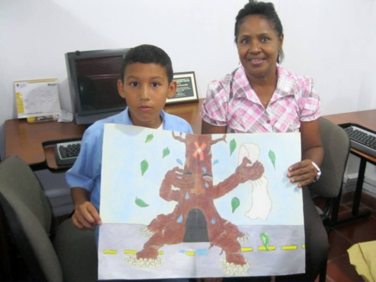 Brayan Pacheco junto a la profesora Rocío Herrera mostrando el dibujo ganador.