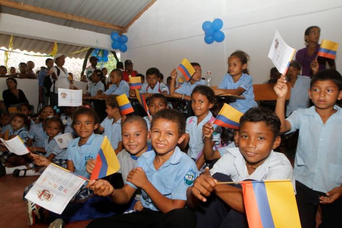 Los niños de Guamanga festejaron con banderas de Colombia el estreno de la nueva escuela. JULIO CASTAÑO - EL UNIVERSAL