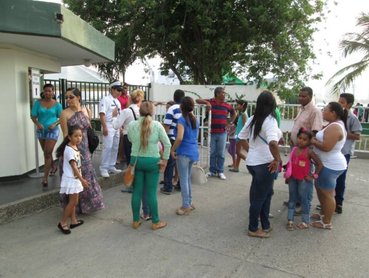 La gente le pedía explicaciones a un oficial naval, del porqué no se estaba cumpliendo el horario anunciado de ingreso para el público que deseaba conocer el buque holandés.