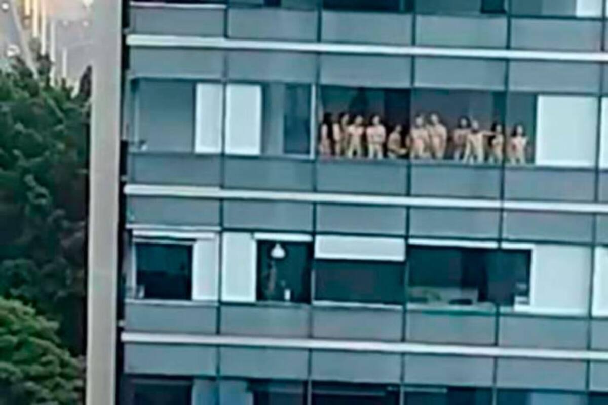 Video: hombres y mujeres salen desnudos en un edificio