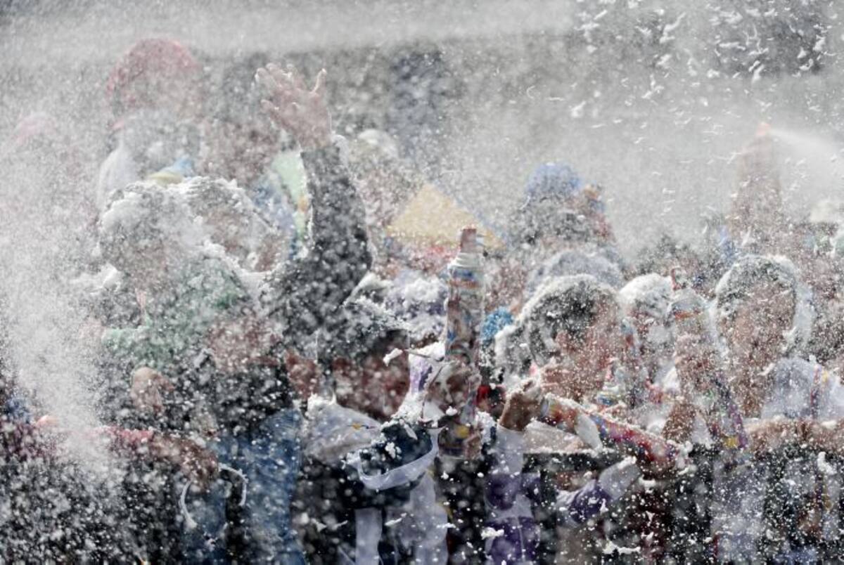 Pese a la fina lluvia, miles de personas, cubiertas por ponchos de plástico, jugaban a lanzarse espuma y harina, al paso de los bailarines. AFP LUIS ROBAYO