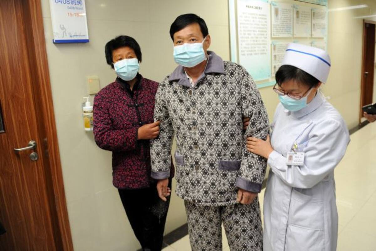 Un paciente de H7N9 de la gripe aviar es guiado por una enfermera después de su recuperación y la aprobación para el alta hospitalaria en Bozhou, China. AFP STR