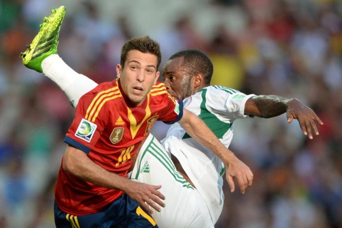 El español Jordi Alba y el nigeriano Sunday Mba. AFP EITAN ABRAMOVICH
