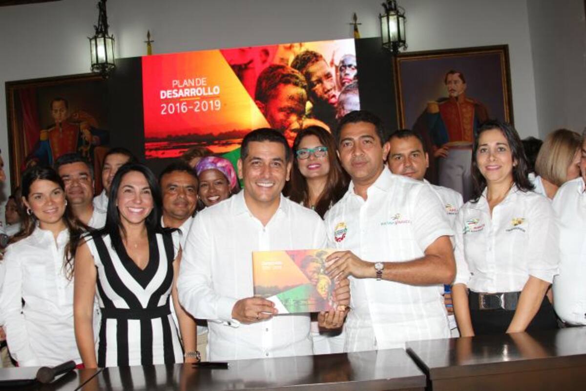 El gobernador de Bolívar, Dumek Turbay; y el presidente de la Asamblea, Jorge Redondo; sostienen el Plan de Desarrollo, Bolívar Sí Avanza, tras la firma y sanción del documento que será la carta de gestión para el cuatrienio. Los acompañan miembros del gabinete y el equipo asesor del Plan. ÓSCAR DÍAZ