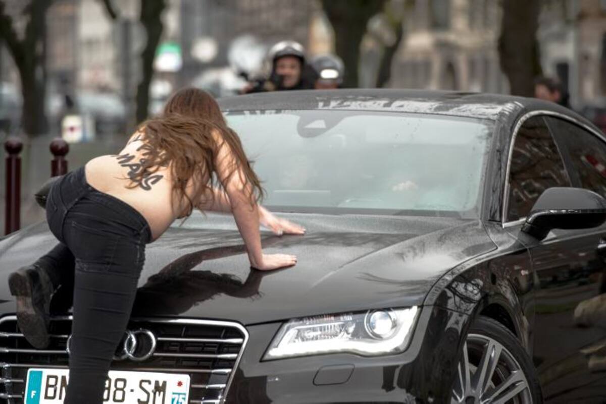 La llegada de Strauss-Kahn al tribunal de Lille, norte de Francia, fue tumultuosa debido a que tres mujeres del movimiento Femen con los pechos desnudos se abalanzaron sobre su automóvil. AFP DENIS CHARLET