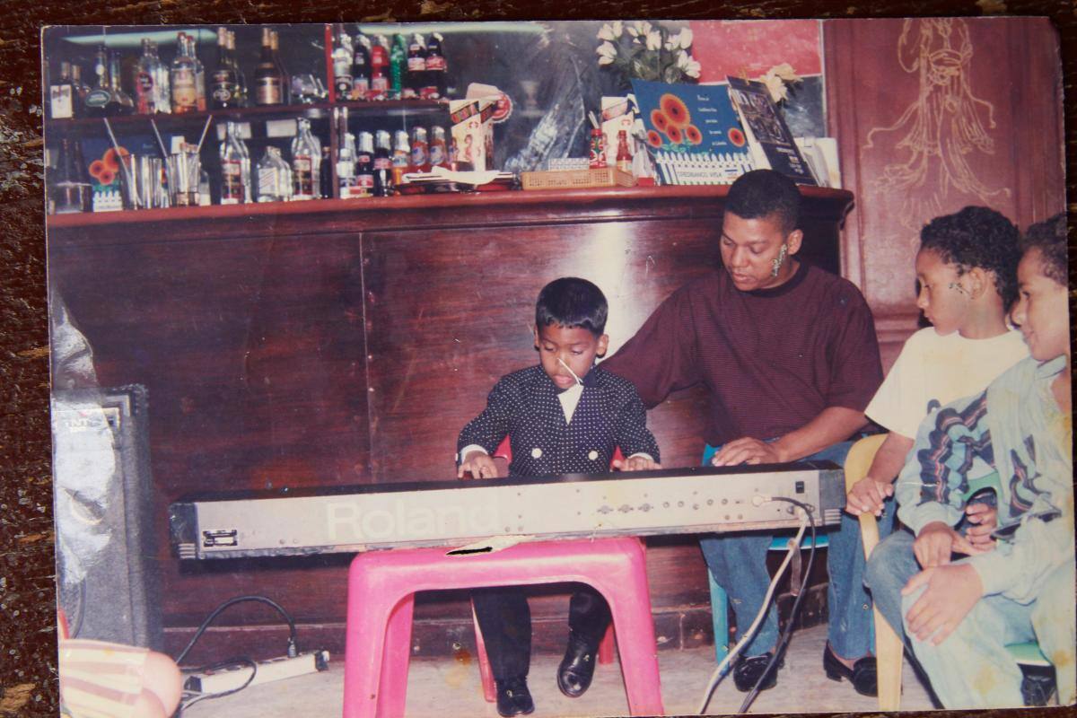 Víctor Del Real y su hijo Cristian tocando el piano.