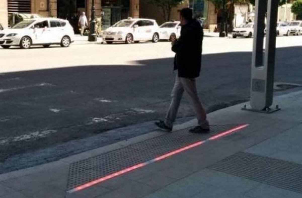 Semáforos en el suelo para peatones con celular. Twitter