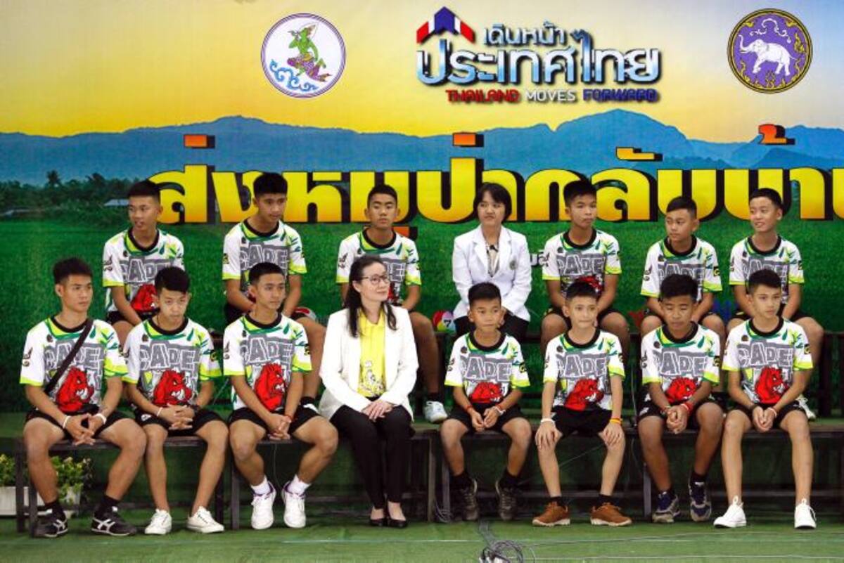 Los doce niños y el entrenador (a la izquierda) rescatados del interior de una cueva en el norte de Tailandia hacen su primera aparición pública junto a psicólogos infantiles, después de que abandonaran el hospital de Chiangrai Prachanukroh, en la provincia de Chiang Rai, Tailandia. EFE PONGMANAT TASIRI