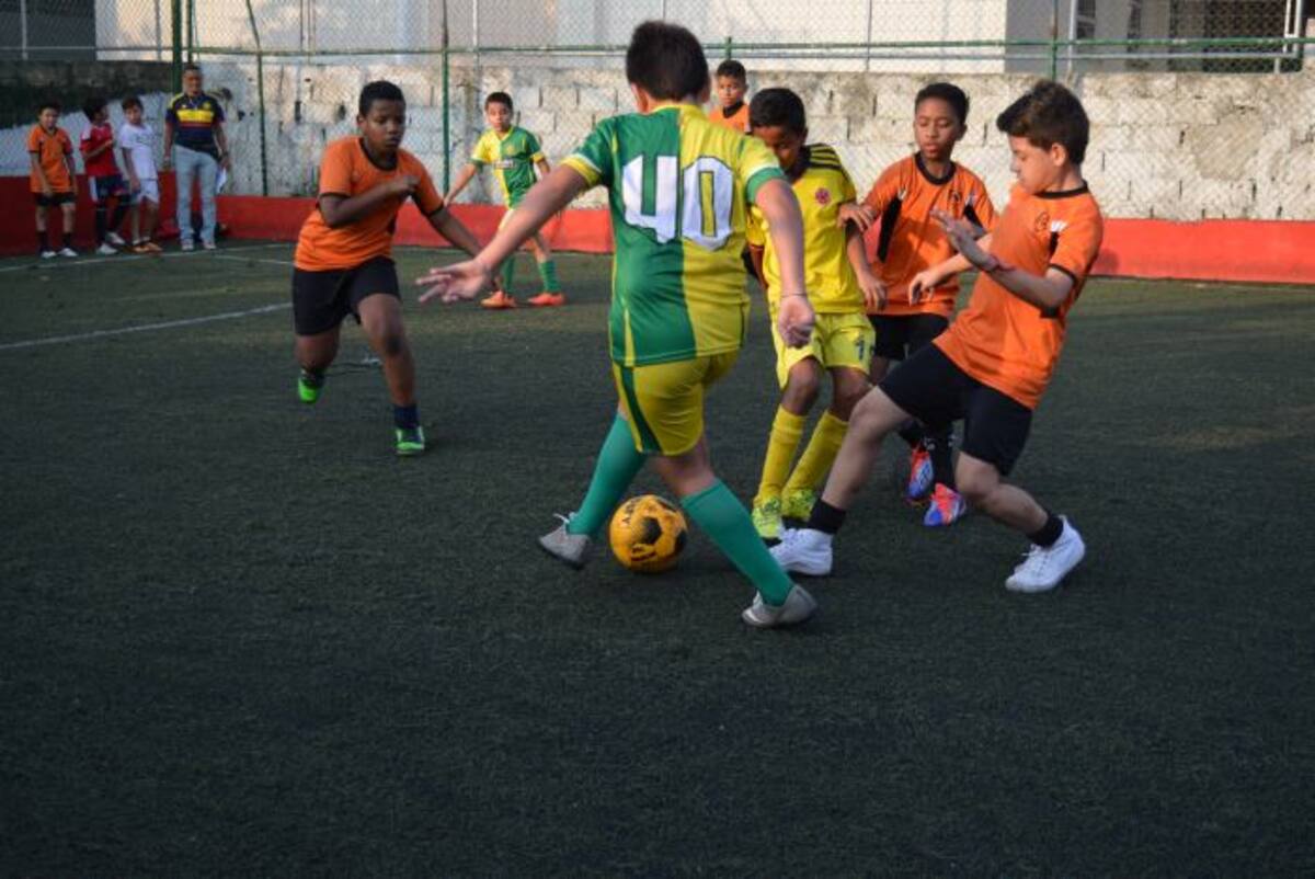 Encuentro amistoso de fútbol infantil entre las escuelas Independiente Cartagena (de amarillo con verde) y Atlético Los Alpes (de salmón con negro). EL UNIVERSAL