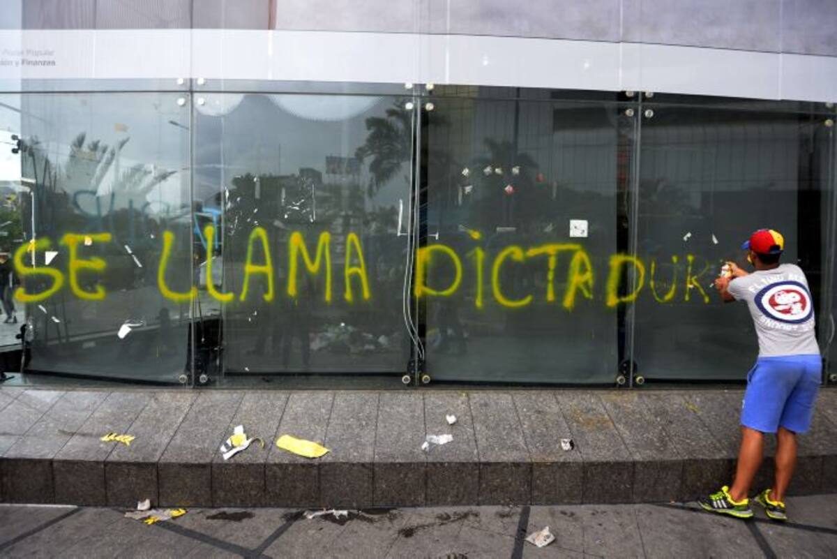Un manifestante dibuja una frase en un vidrio durante las protestas de oposición. AFP JUAN BARRETO