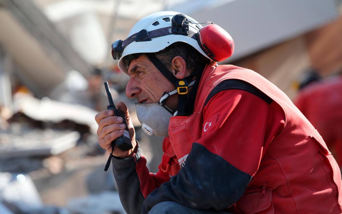 Un miembro del equipo de rescate se comunica a través de un transceptor de mano durante las operaciones de búsqueda en el sitio de un edificio derrumbado después de un gran terremoto en Adiyaman, Turquía.