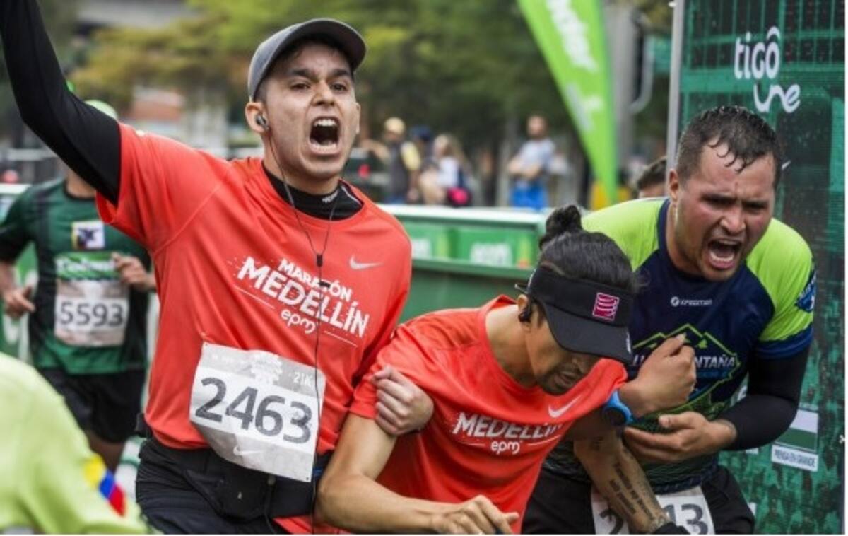 Juan Camilo Arboleda (centro) cruzó la meta con ayuda de dos corredores. TOMADO DE ELCOLOMBIANO.COM